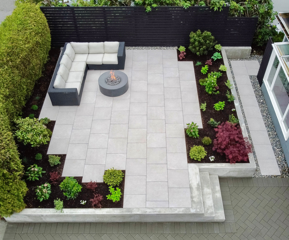 Ejemplo de jardín moderno de tamaño medio en patio trasero con macetero elevado, exposición total al sol, adoquines de hormigón y con madera