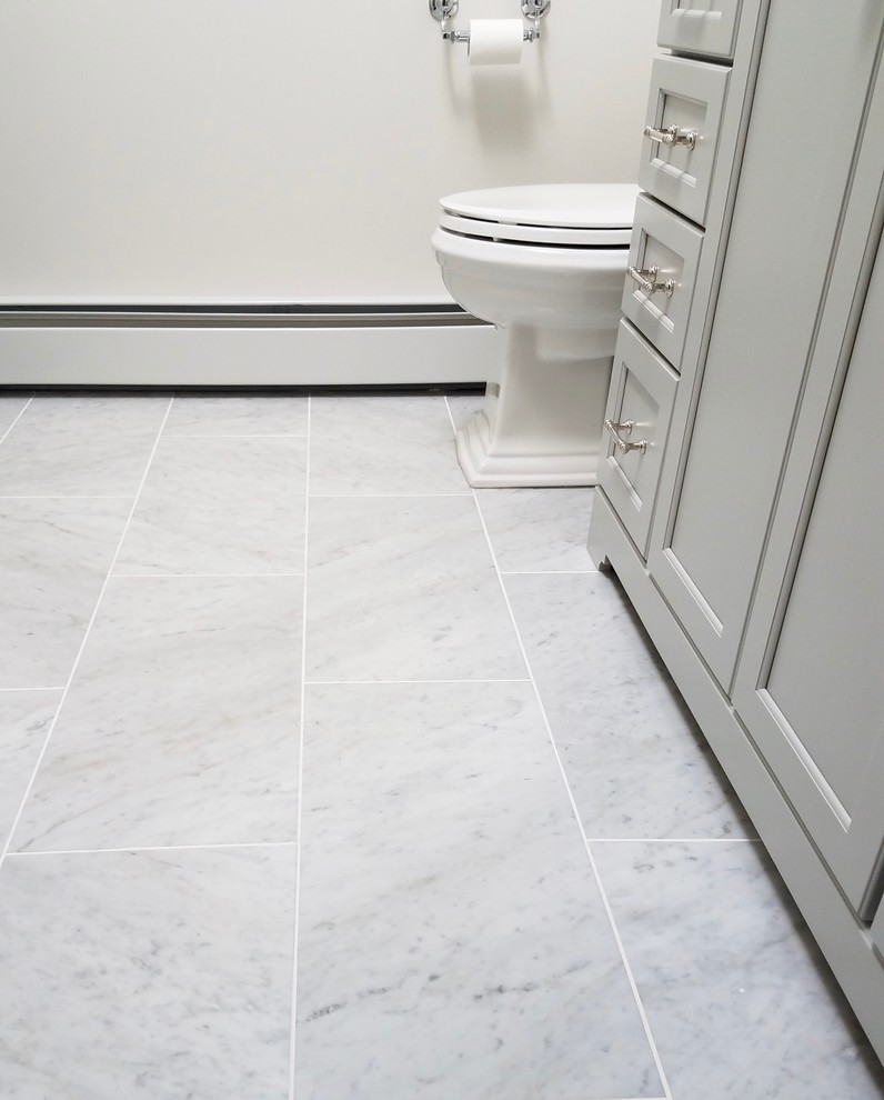 Photo of a mid-sized transitional 3/4 bathroom in Bridgeport with recessed-panel cabinets, grey cabinets, an alcove shower, a one-piece toilet, white walls, marble floors, an undermount sink, marble benchtops, grey floor, a hinged shower door, gray tile and subway tile.