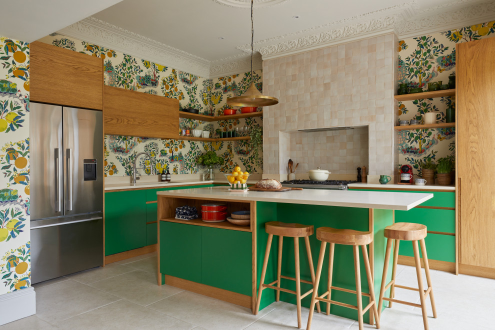 На фото: угловая кухня в стиле фьюжн с обеденным столом, зелеными фасадами, столешницей из акрилового камня, островом, бежевой столешницей и обоями на стенах с