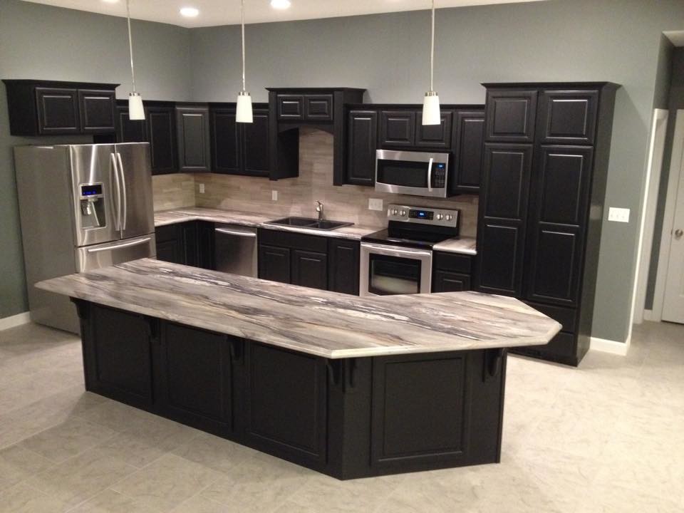 Example of a l-shaped kitchen design with black cabinets, gray backsplash, stainless steel appliances and an island