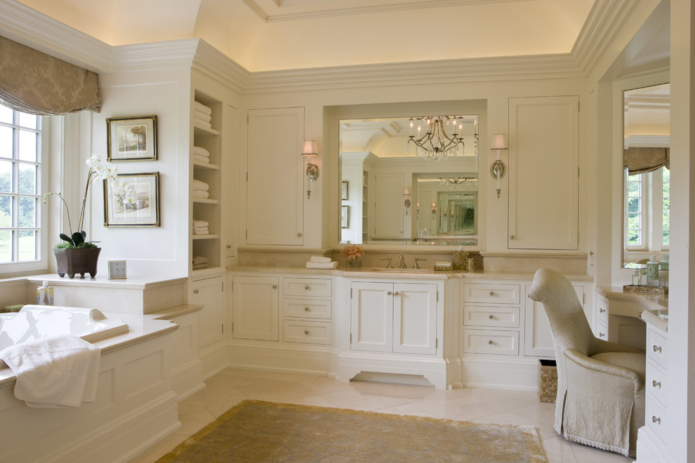 Photo of a traditional bathroom in Boston with recessed-panel cabinets, white cabinets and a drop-in tub.