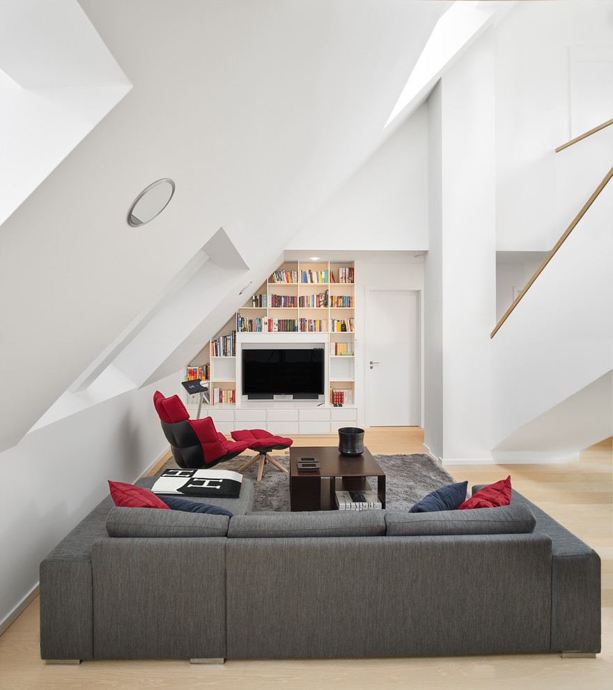 Contemporary living room in Munich with white walls, light hardwood floors, a concealed tv and beige floor.