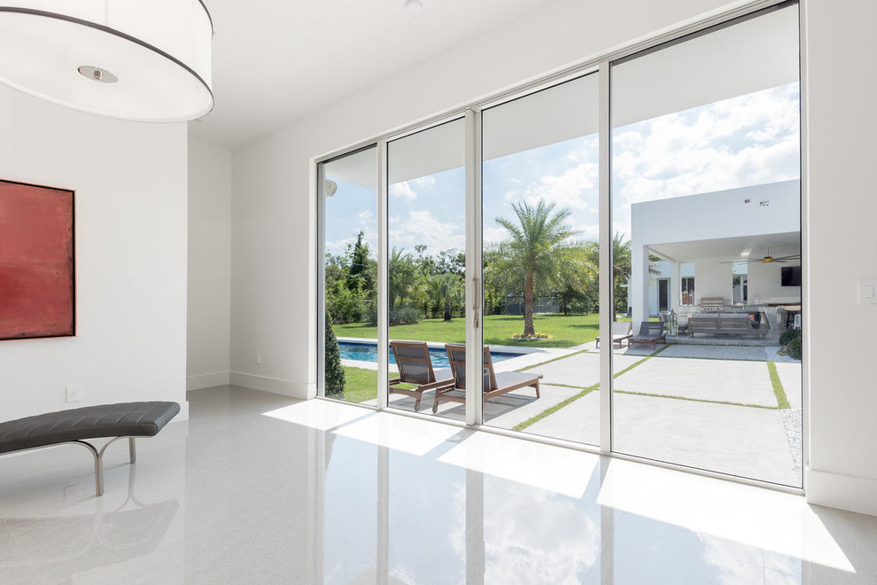Photo of a large modern master bedroom in Miami with white walls, concrete floors, no fireplace and grey floor.
