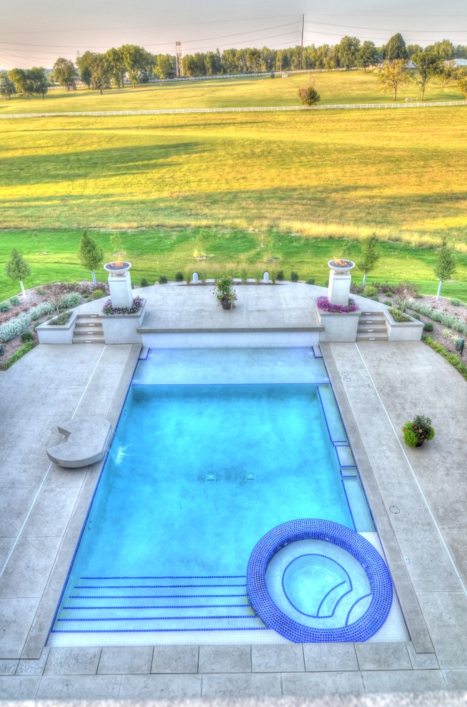 Design ideas for a large transitional backyard rectangular natural pool in Cedar Rapids with a hot tub and concrete pavers.