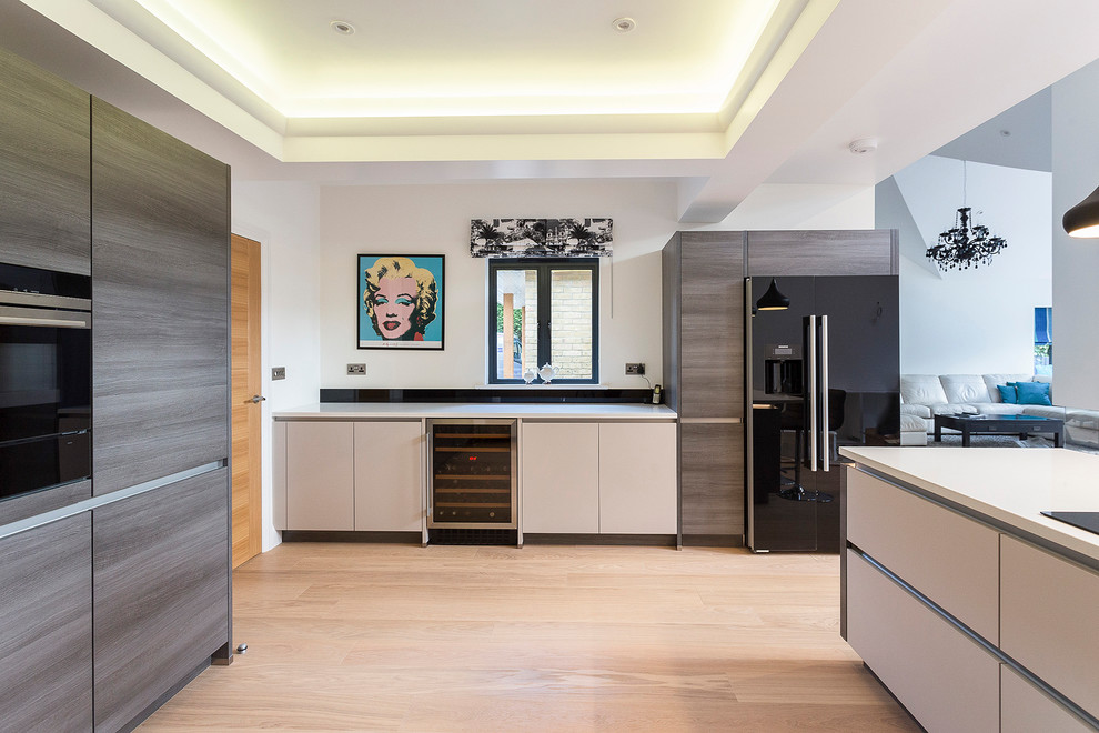 Mid-sized contemporary u-shaped eat-in kitchen in London with flat-panel cabinets, medium wood cabinets, black splashback, glass sheet splashback and a peninsula.