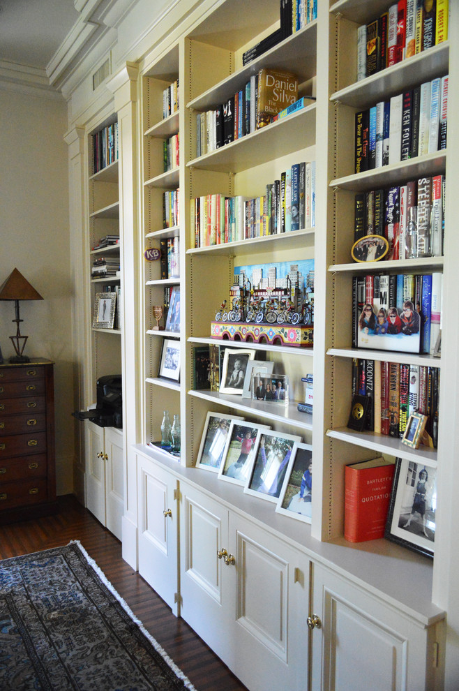Traditional home office in New Orleans with a library, a freestanding desk and brown floor.