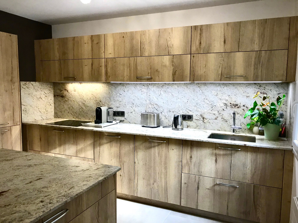 Idéer för att renovera ett stort funkis beige beige kök med öppen planlösning, med en integrerad diskho, luckor med profilerade fronter, skåp i mellenmörkt trä, granitbänkskiva, beige stänkskydd, integrerade vitvaror, klinkergolv i keramik, en köksö och beiget golv