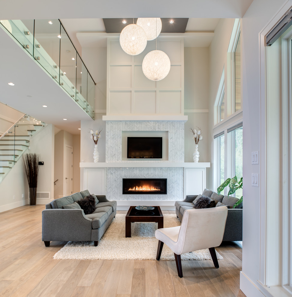 Mid-sized transitional open concept living room in Vancouver with white walls, light hardwood floors, a standard fireplace, a stone fireplace surround, a wall-mounted tv and beige floor.