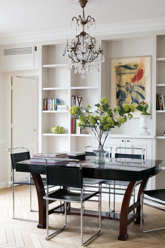 Mid-sized transitional open plan dining in Paris with light hardwood floors and white walls.