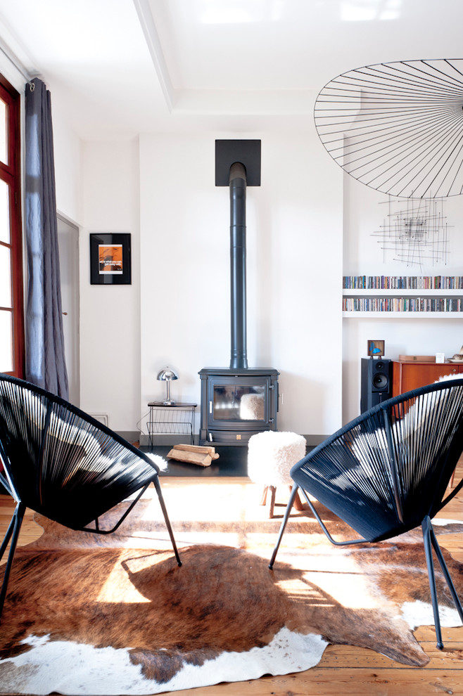 Photo of a large scandinavian open concept living room in Bordeaux with white walls, medium hardwood floors, a wood stove and no tv.