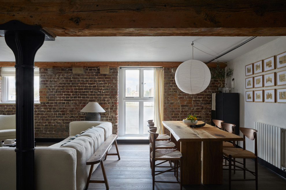 Réalisation d'une salle à manger ouverte sur le salon urbaine avec un mur blanc, parquet foncé, un sol marron et un mur en parement de brique.