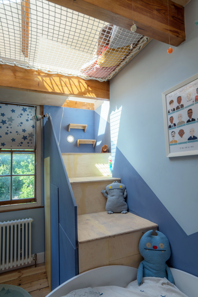 Modelo de habitación de invitados tradicional grande sin chimenea con paredes azules, suelo de madera en tonos medios y suelo marrón
