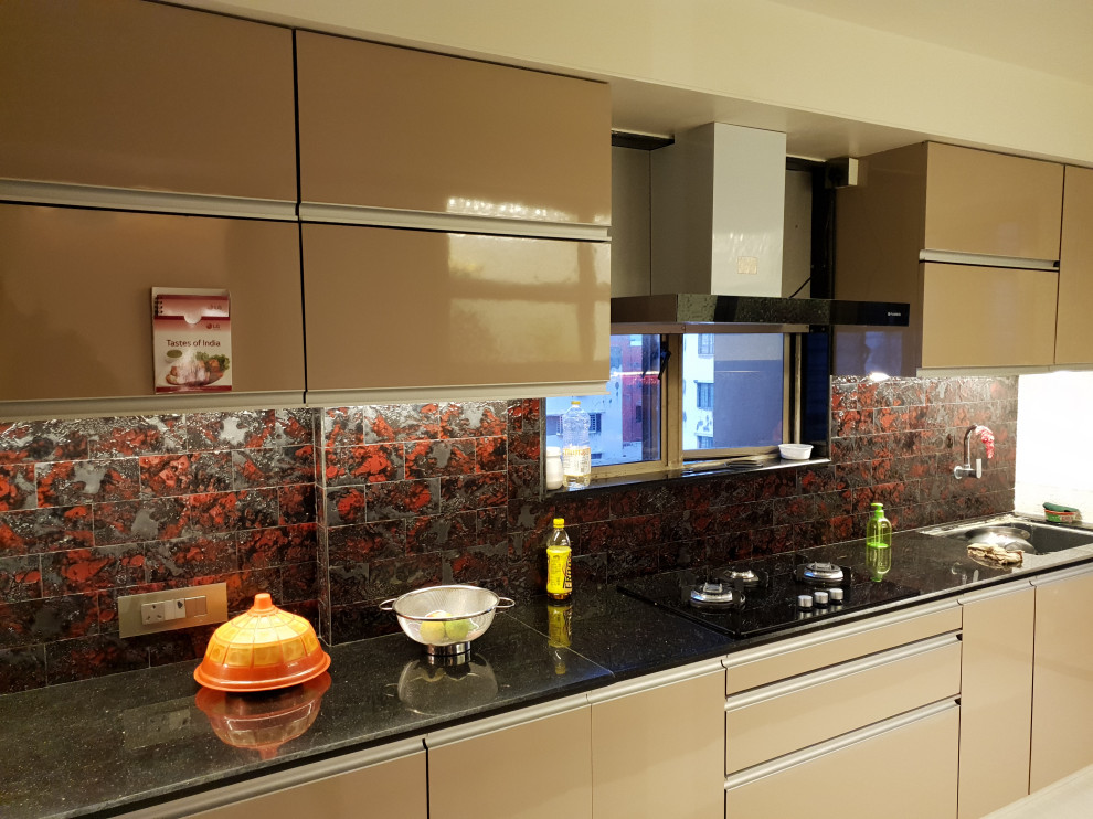 Immagine di una cucina minimal di medie dimensioni con ante di vetro, ante beige, top in granito, paraspruzzi a effetto metallico, elettrodomestici neri, pavimento in marmo e soffitto ribassato