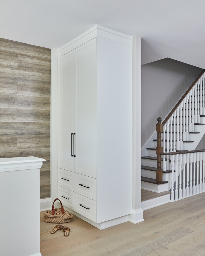 Example of a small transitional light wood floor and wood wall entryway design in Toronto with beige walls and a white front door