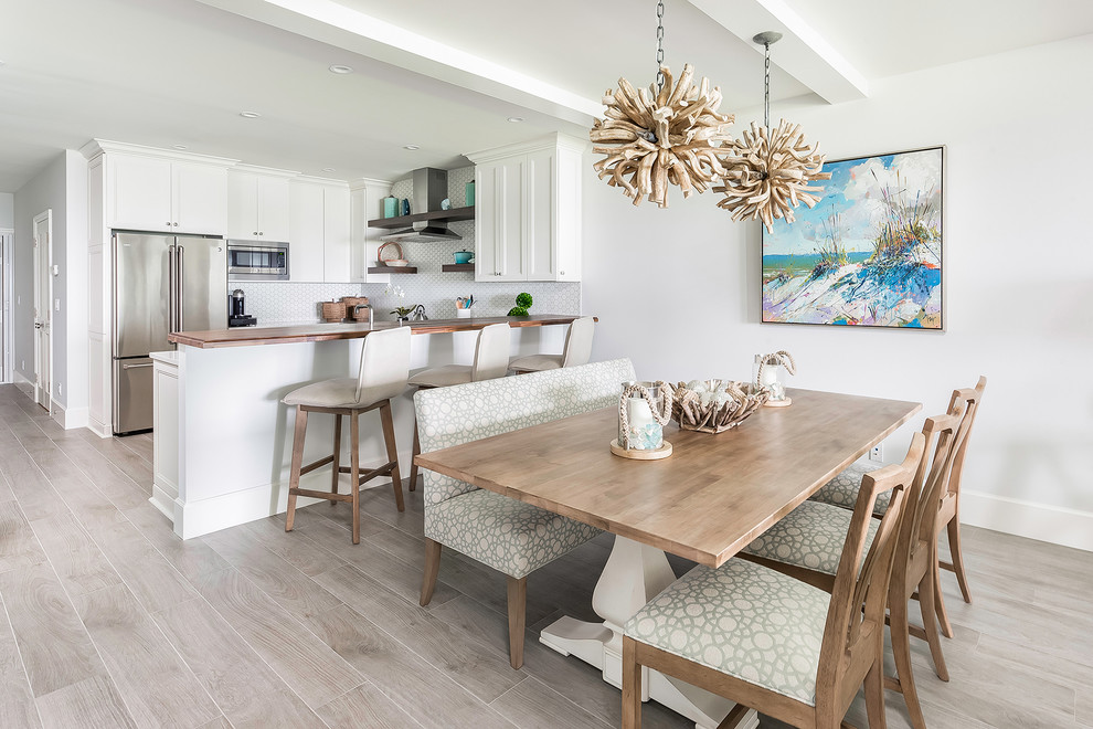 Design ideas for a beach style kitchen/dining combo with white walls and grey floor.