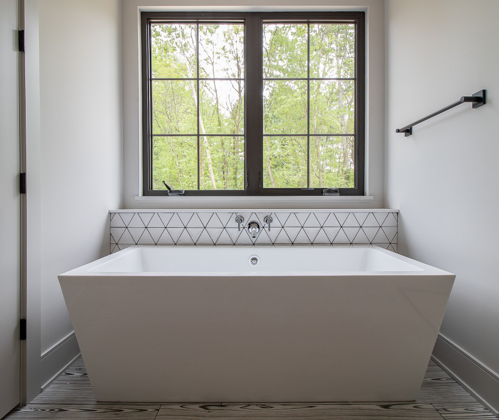 Пример оригинального дизайна: большая главная ванная комната в классическом стиле с фасадами с утопленной филенкой, темными деревянными фасадами, отдельно стоящей ванной, серой плиткой, керамогранитной плиткой, серыми стенами, светлым паркетным полом, коричневым полом, белой столешницей, нишей, тумбой под две раковины и встроенной тумбой