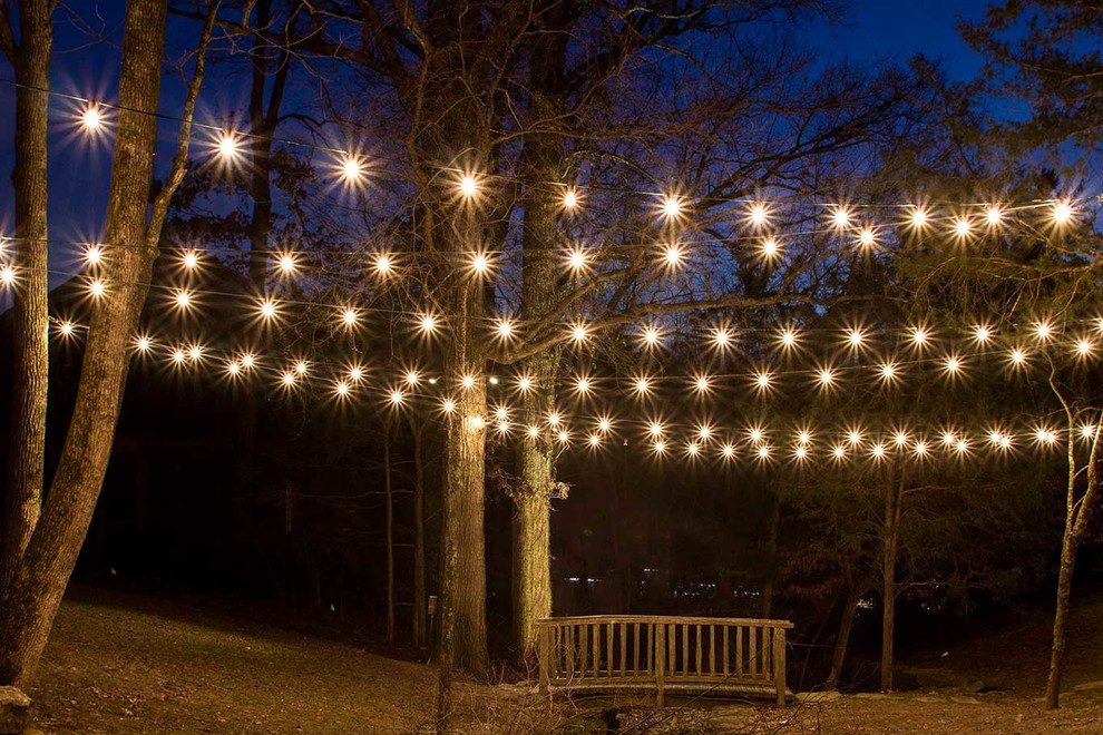 Photo of a mid-sized rustic partial sun backyard stone landscaping in Nashville.