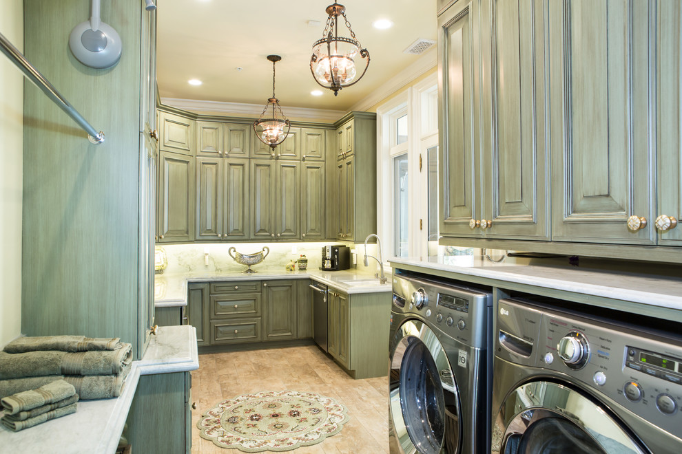 Photo of a large traditional u-shaped utility room in Los Angeles with raised-panel cabinets, green cabinets, quartzite benchtops, travertine floors and a side-by-side washer and dryer.