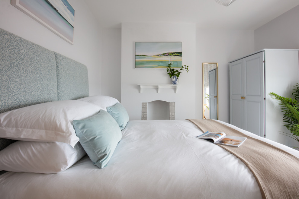 コーンウォールにある中くらいなヴィクトリアン調のおしゃれな客用寝室 (白い壁、カーペット敷き、標準型暖炉、タイルの暖炉まわり、ベージュの床)