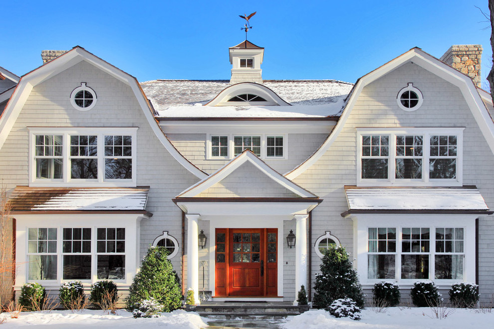 This is an example of a large country two-storey white house exterior in New York with wood siding, a gambrel roof and a shingle roof.