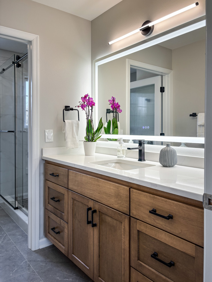 Mid-sized transitional kids' white tile and porcelain tile porcelain tile, gray floor and single-sink corner shower photo in Milwaukee with recessed-panel cabinets, dark wood cabinets, a two-piece toilet, gray walls, an undermount sink, quartz countertops, white countertops, a niche and a built-in vanity