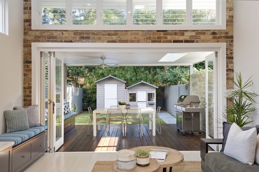 Photo of a mid-sized beach style backyard deck in Sydney with a roof extension.