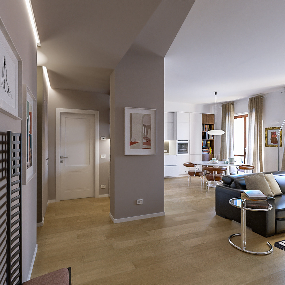 Photo of a mid-sized contemporary open concept living room in Milan with beige walls, light hardwood floors and a wall-mounted tv.