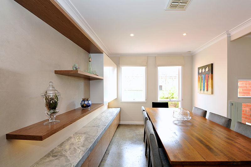 Transitional u-shaped eat-in kitchen in Melbourne with a farmhouse sink, shaker cabinets, white cabinets, granite benchtops, stainless steel appliances, concrete floors and no island.