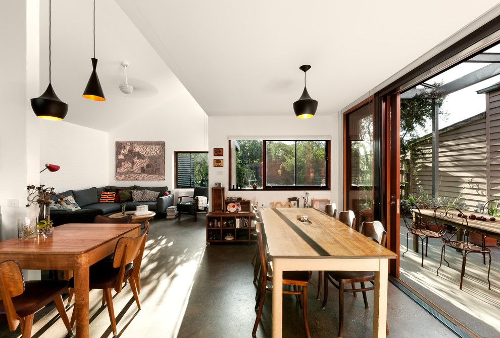 This is an example of a mid-sized eclectic open plan dining in Melbourne with white walls, concrete floors, no fireplace and grey floor.