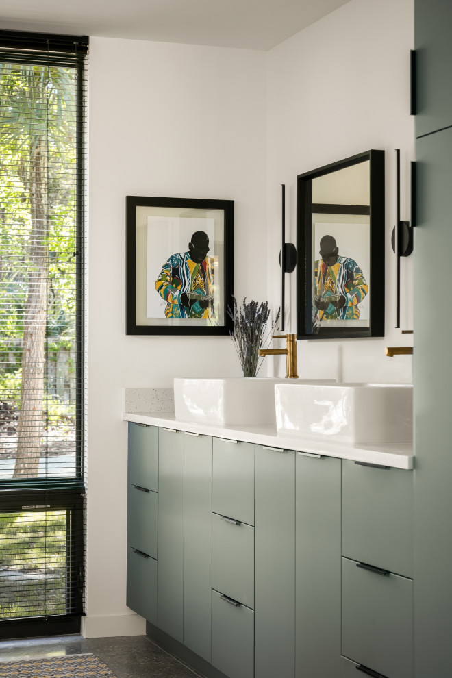 This is an example of a mid-sized contemporary master wet room bathroom in Tampa with flat-panel cabinets, green cabinets, an alcove tub, a two-piece toilet, white tile, porcelain tile, white walls, concrete floors, a vessel sink, engineered quartz benchtops, grey floor, an open shower, white benchtops, an enclosed toilet, a double vanity and a built-in vanity.