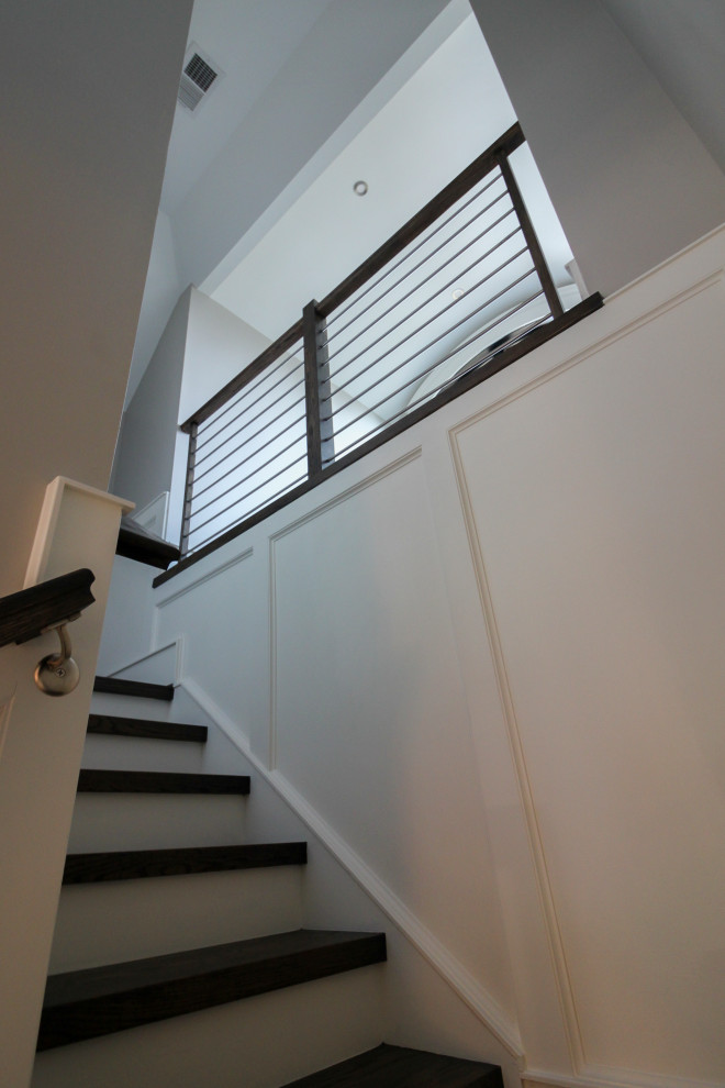 Photo of a large contemporary wood u-shaped staircase in DC Metro with wood risers and mixed railing.
