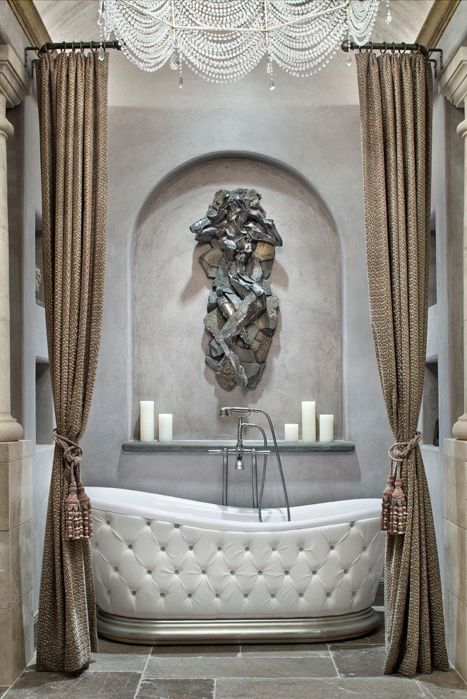 Photo of a mediterranean master bathroom in Houston with a freestanding tub and grey walls.