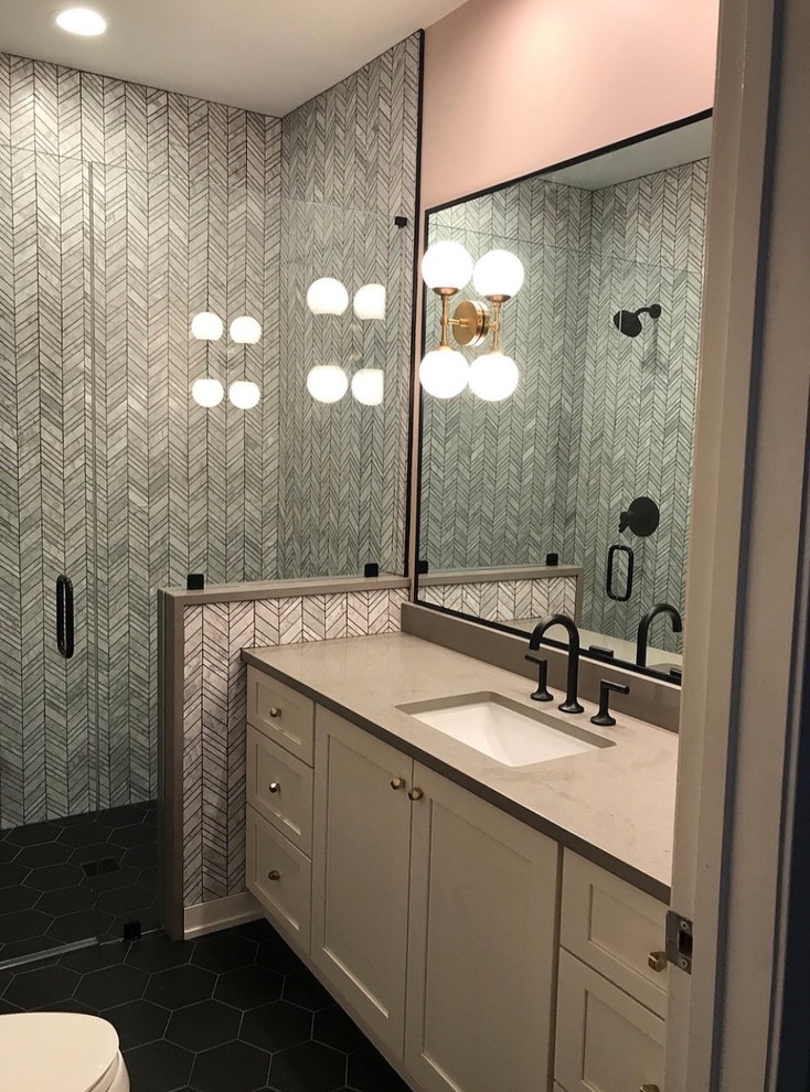 Inspiration for a mid-sized transitional 3/4 bathroom in Chicago with shaker cabinets, white cabinets, an alcove shower, gray tile, marble, pink walls, porcelain floors, an undermount sink, engineered quartz benchtops, black floor, a hinged shower door and grey benchtops.