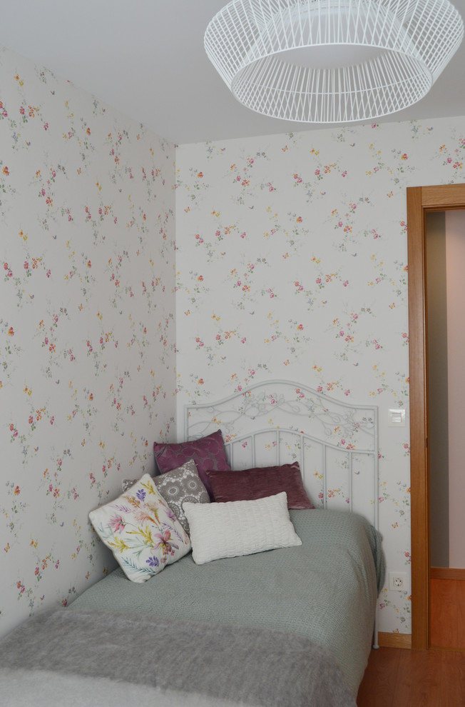 Imagen de dormitorio infantil nórdico con paredes multicolor y suelo de madera en tonos medios