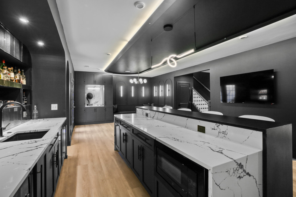 Mid-sized modern home bar in DC Metro with an undermount sink, black cabinets, quartz benchtops, black splashback, glass tile splashback, vinyl floors, beige floor and multi-coloured benchtop.