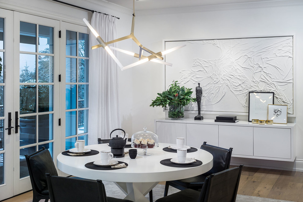 This is an example of a contemporary dining room in Portland with white walls and medium hardwood floors.