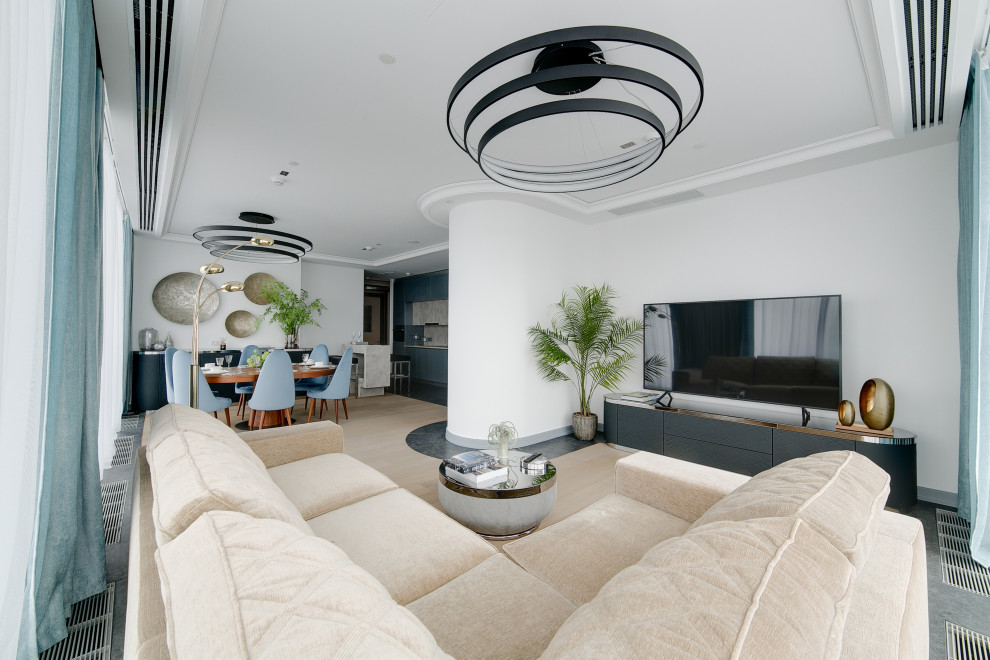 Contemporary open concept living room in Moscow with white walls, light hardwood floors, a freestanding tv, beige floor and recessed.