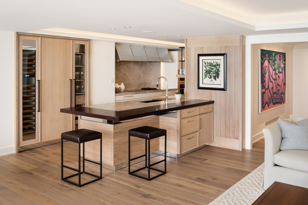 Mid-sized transitional galley brown floor, tray ceiling and medium tone wood floor open concept kitchen photo in Chicago with an undermount sink, flat-panel cabinets, quartzite countertops, a peninsula, light wood cabinets, beige backsplash, paneled appliances and beige countertops