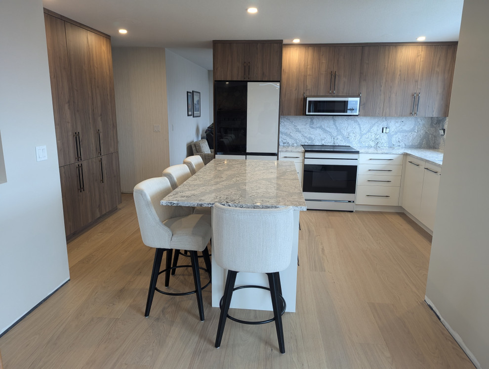 Stylish kitchen featuring integrated appliances, wood cabinets, and stone backsp
