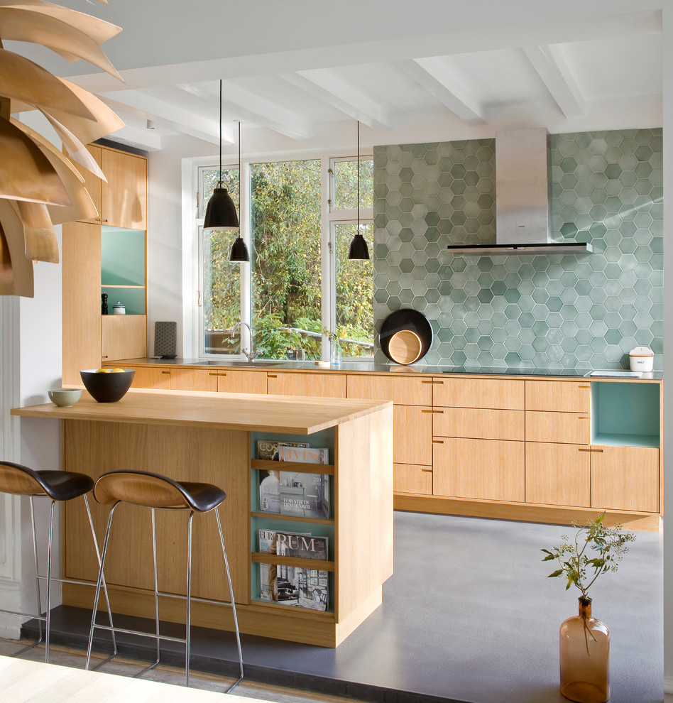 Design ideas for a mid-sized scandinavian galley eat-in kitchen in Copenhagen with flat-panel cabinets, light wood cabinets, green splashback, a peninsula, a drop-in sink, wood benchtops and linoleum floors.