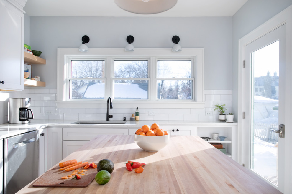 Inspiration for a mid-sized transitional l-shaped light wood floor, brown floor and coffered ceiling eat-in kitchen remodel in Minneapolis with an undermount sink, shaker cabinets, white cabinets, quartz countertops, white backsplash, subway tile backsplash, stainless steel appliances, an island and white countertops