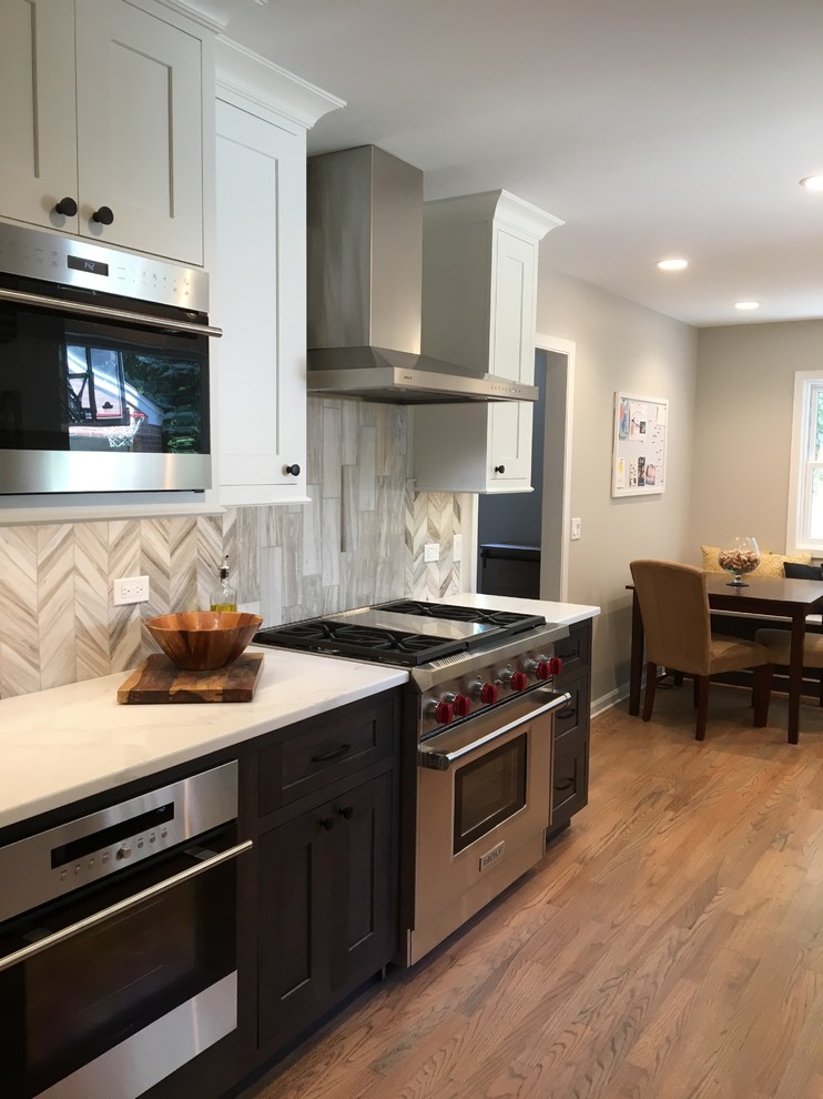 Small transitional galley medium tone wood floor and brown floor eat-in kitchen photo in Chicago with a farmhouse sink, shaker cabinets, gray cabinets, quartzite countertops, gray backsplash, stone tile backsplash, stainless steel appliances, no island and white countertops