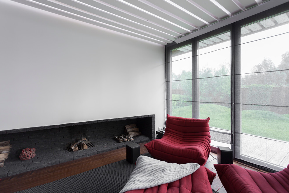 Свежая идея для дизайна: парадная гостиная комната в современном стиле с белыми стенами, ковровым покрытием, стандартным камином и фасадом камина из камня - отличное фото интерьера
