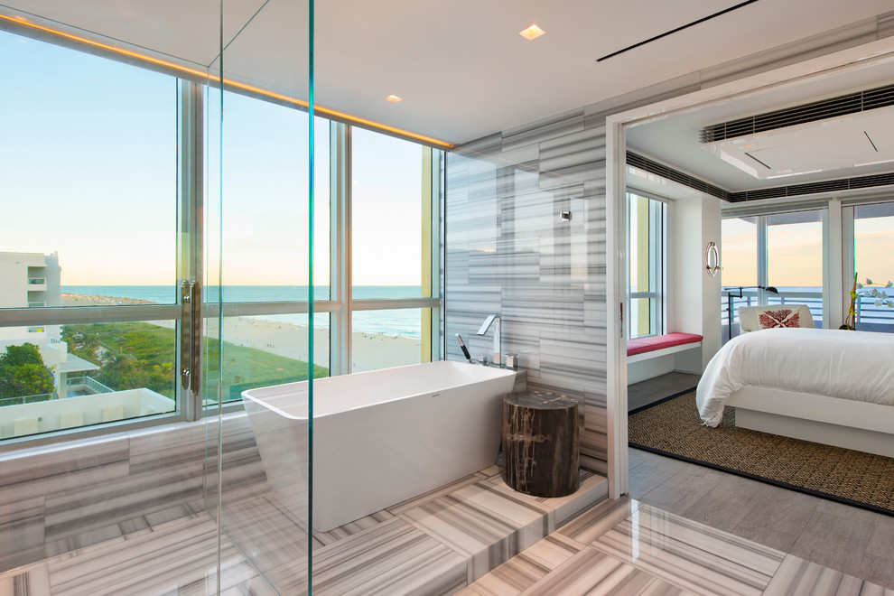 This is an example of a large contemporary master bathroom in Miami with a freestanding tub, white tile, an open shower, multi-coloured walls, multi-coloured floor and an open shower.
