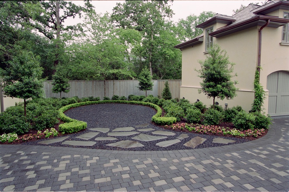 Photo of a mid-sized traditional front yard full sun driveway for spring in Houston with gravel.