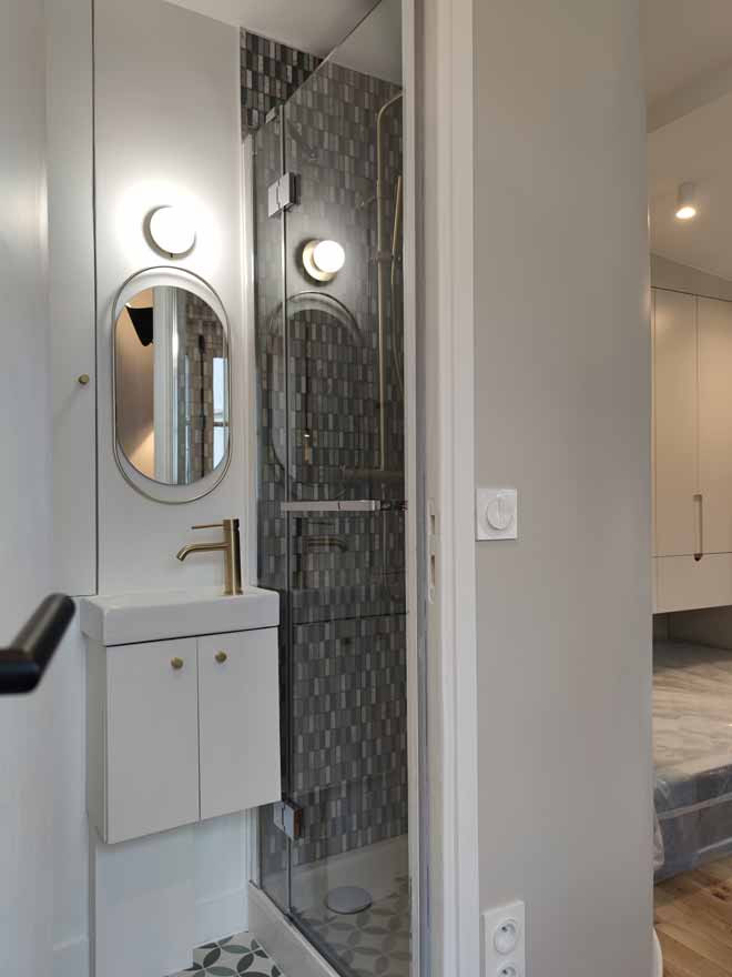 Photo of a small contemporary shower room bathroom in Paris with beaded cabinets, white cabinets, a corner shower, a wall mounted toilet, green tiles, mosaic tiles, white walls, cement flooring, a console sink, limestone worktops, green floors, a hinged door, white worktops, a single sink and a floating vanity unit.