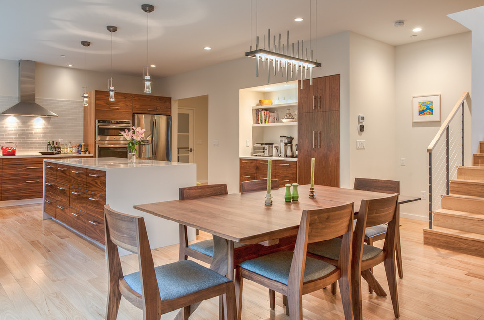 This is an example of a mid-sized contemporary open plan dining in Burlington with white walls, light hardwood floors, no fireplace and brown floor.