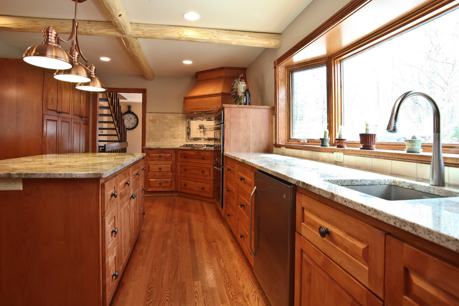 Inspiration for a large rustic u-shaped medium tone wood floor eat-in kitchen remodel in Milwaukee with a single-bowl sink, shaker cabinets, medium tone wood cabinets, granite countertops, beige backsplash, ceramic backsplash, stainless steel appliances and an island