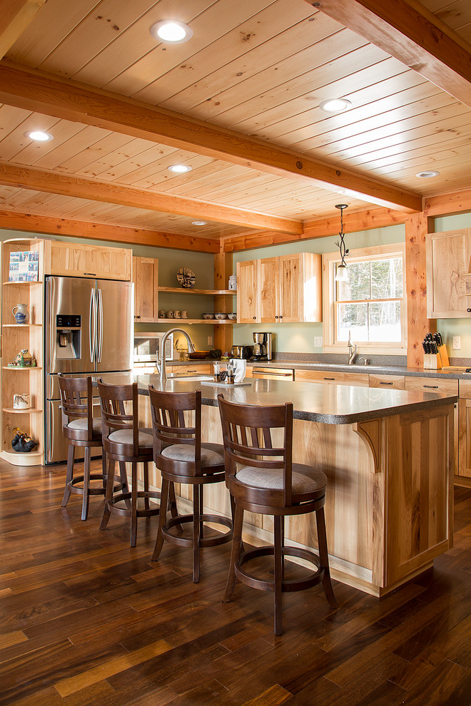 Example of a large mountain style u-shaped dark wood floor eat-in kitchen design in Burlington with an undermount sink, shaker cabinets, medium tone wood cabinets, solid surface countertops, stainless steel appliances and an island