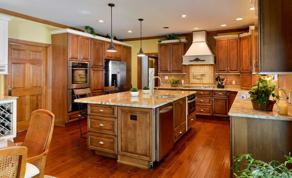 Inspiration for a large transitional u-shaped medium tone wood floor eat-in kitchen remodel with beaded inset cabinets, medium tone wood cabinets, granite countertops, beige backsplash, mosaic tile backsplash, stainless steel appliances and an island
